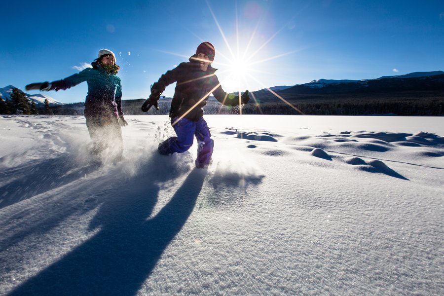 JasperNP-Snowshoeing-Couple-Running-Beside-Lake-Credit-Parks-Canada-Adam-Greenberg.JPG
